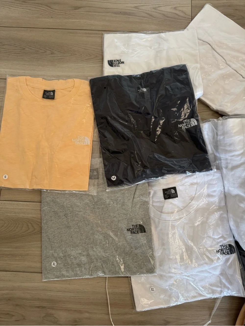 6pcs for $40. The North Face Logo Tee – Peach, Black, Gray & White Assortment